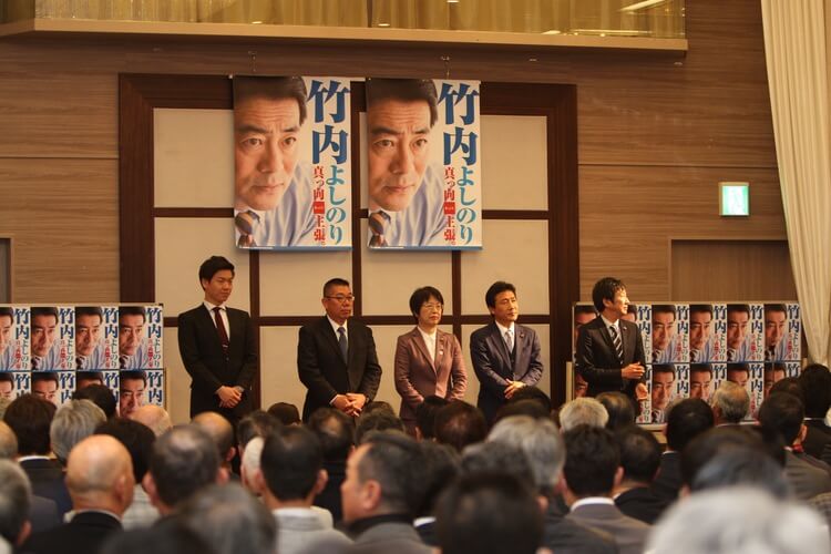 竹内よしのり県議の企業・団体決起大会にて並ぶ、山本りょうたろう市長選候補、井田ひろやす市議会議員候補、すどう京子市議会議員候補、松本康夫市議会議員候補、波多野亘市議会議員候補